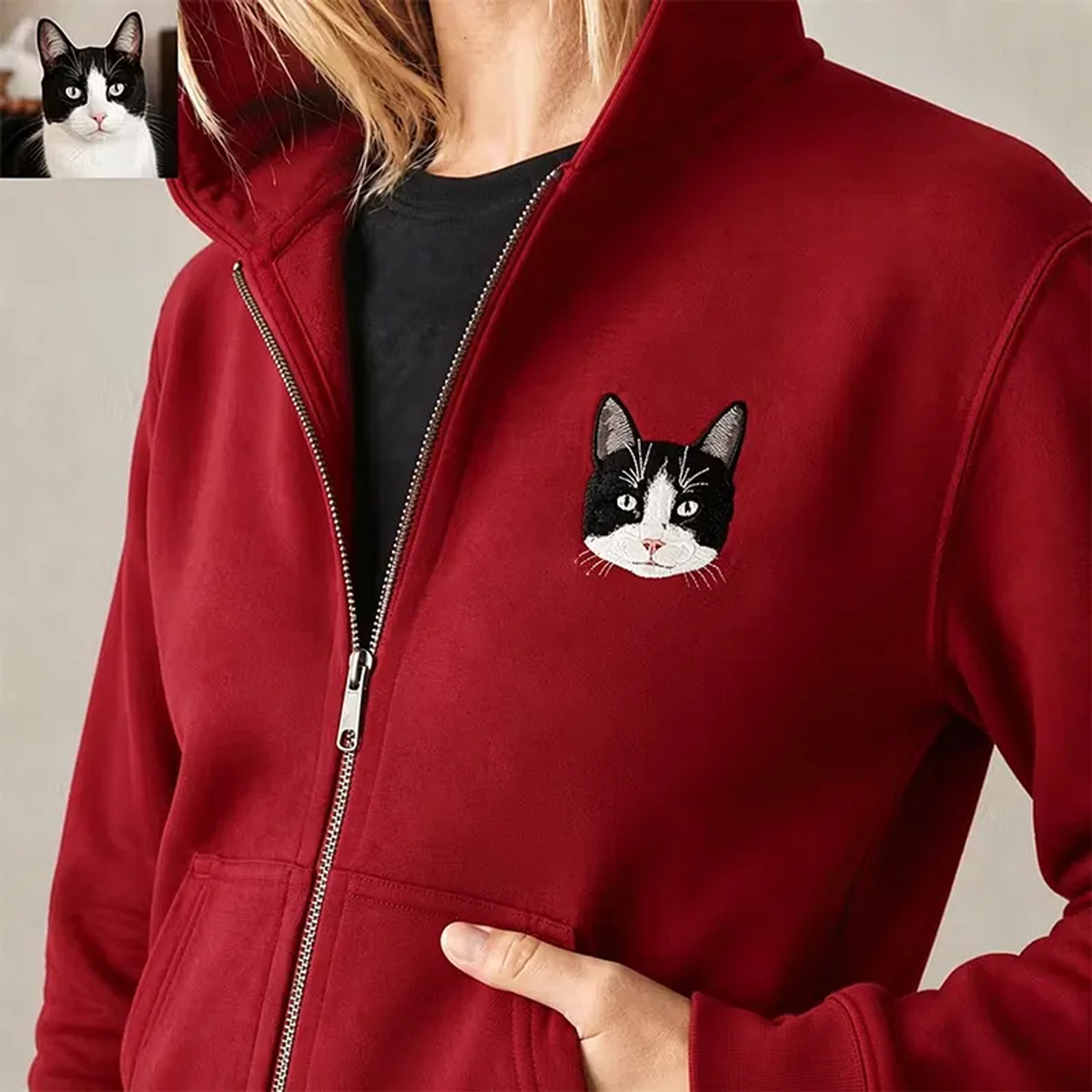 Red zip hoodie with embroidered black and white cat portrait