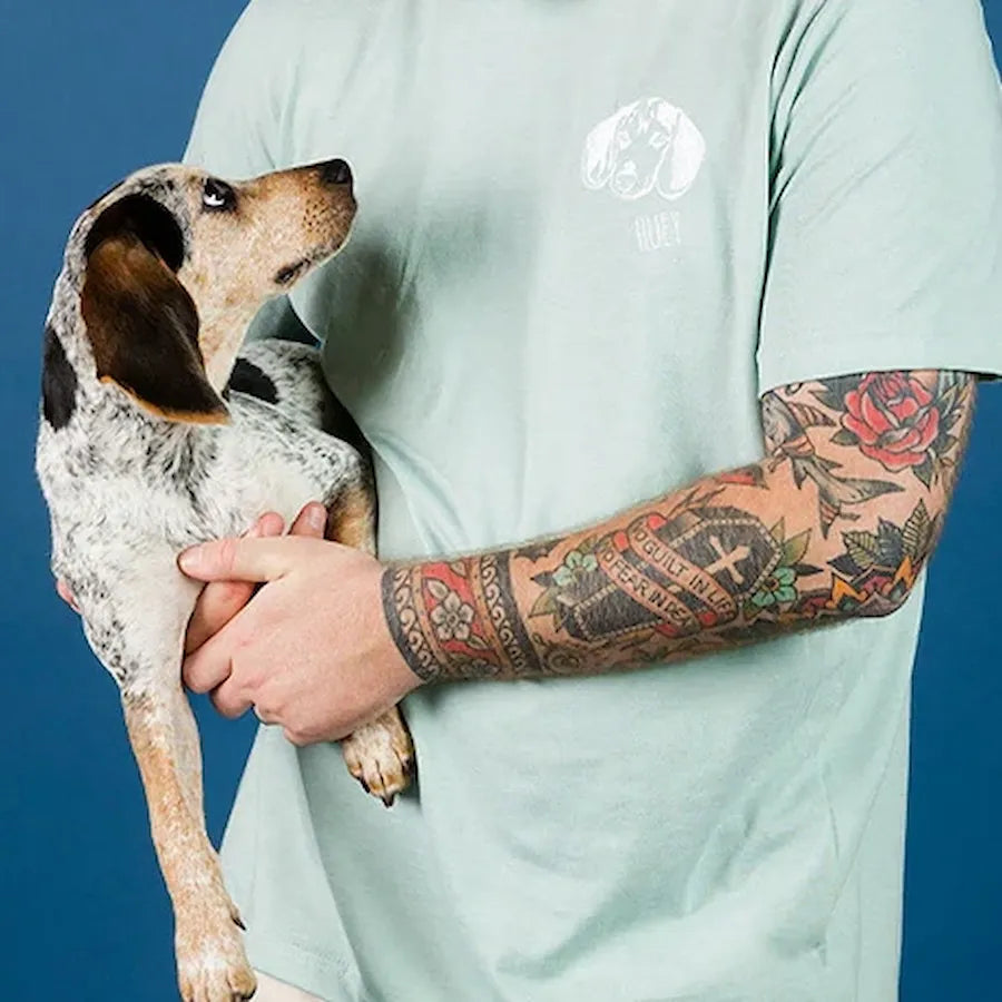 Mint pet portrait tee worn by a tattooed model holding a small dog