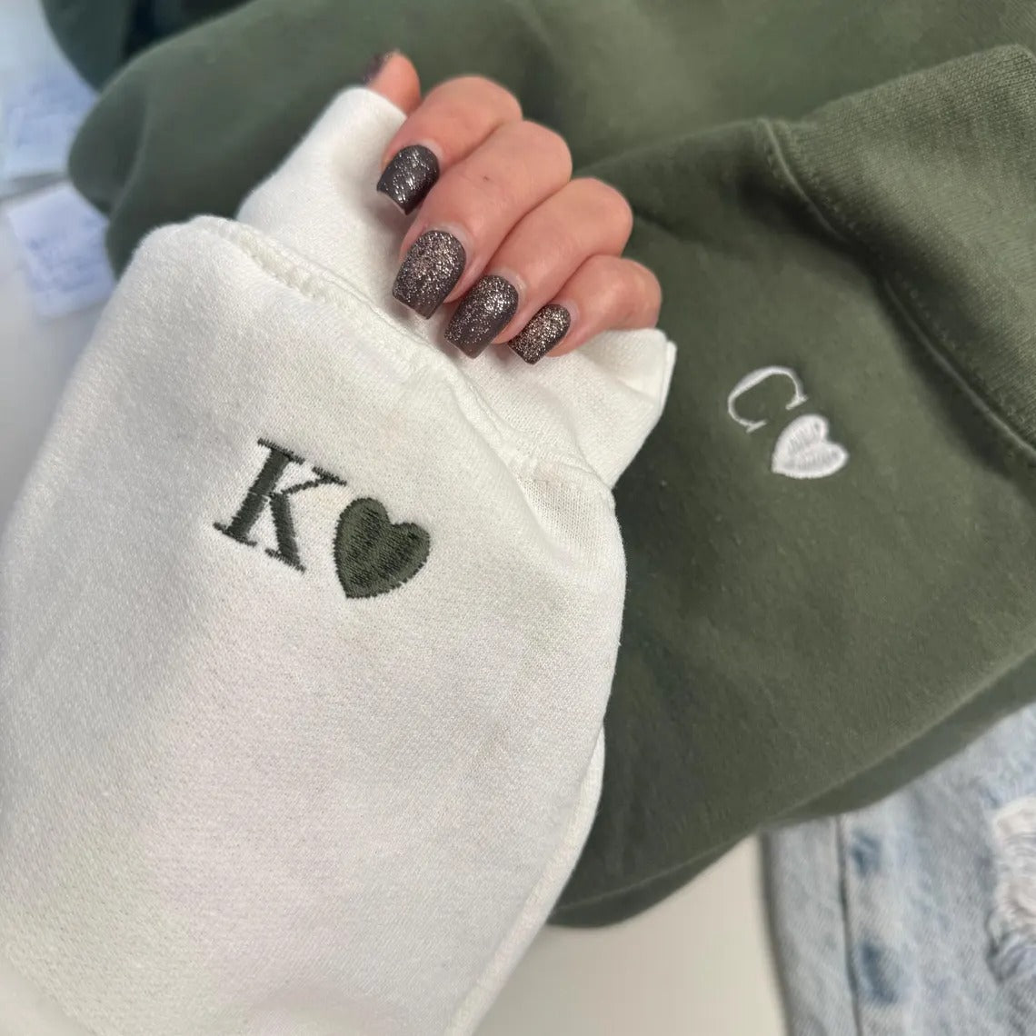 Couple holding hands with personalized initial and heart sleeve embroidery