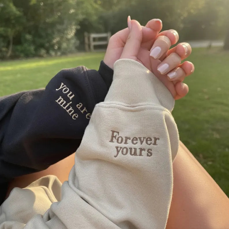 Couple holding hands with You are mine and Forever yours sleeve messages