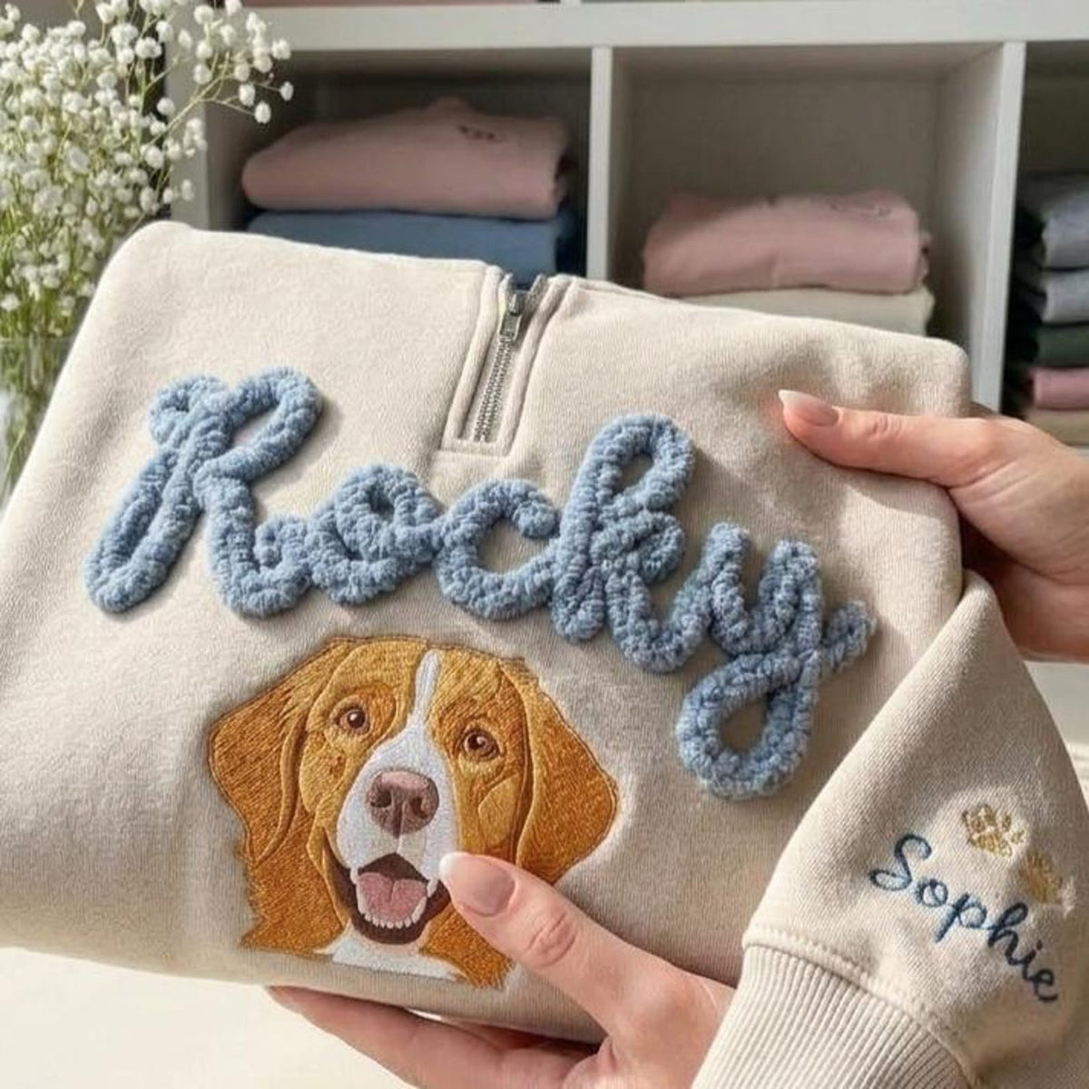 Close-up of raised Rocky lettering and dog face embroidery on cream quarter zip
