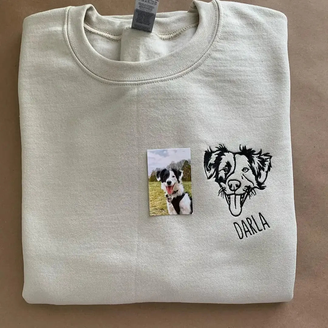 Line art dog portrait embroidered on the chest of a sand sweatshirt with the name Darla, shown next to the original photo