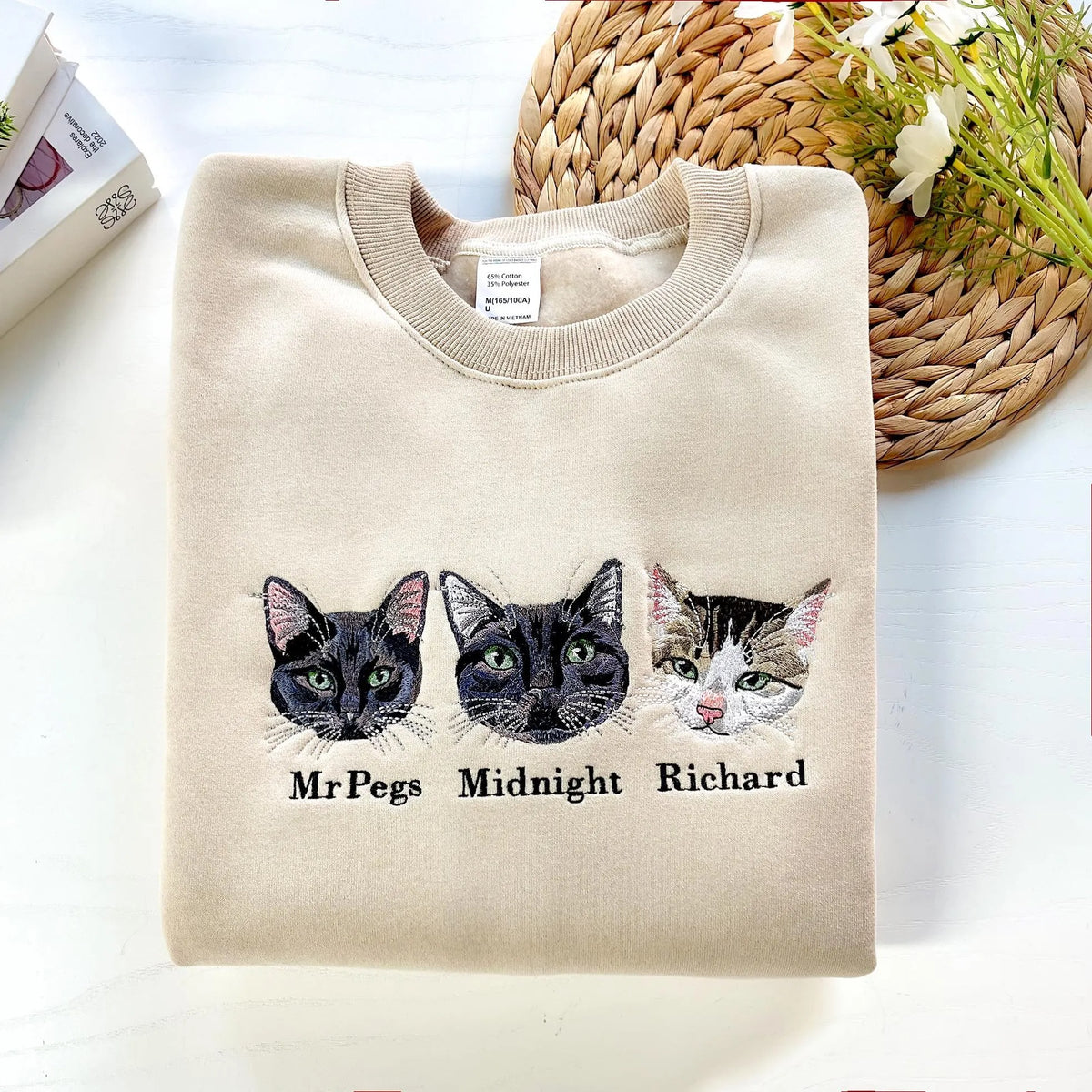 Folded cream sweatshirt with Mr Pegs Midnight and Richard cat portraits and names