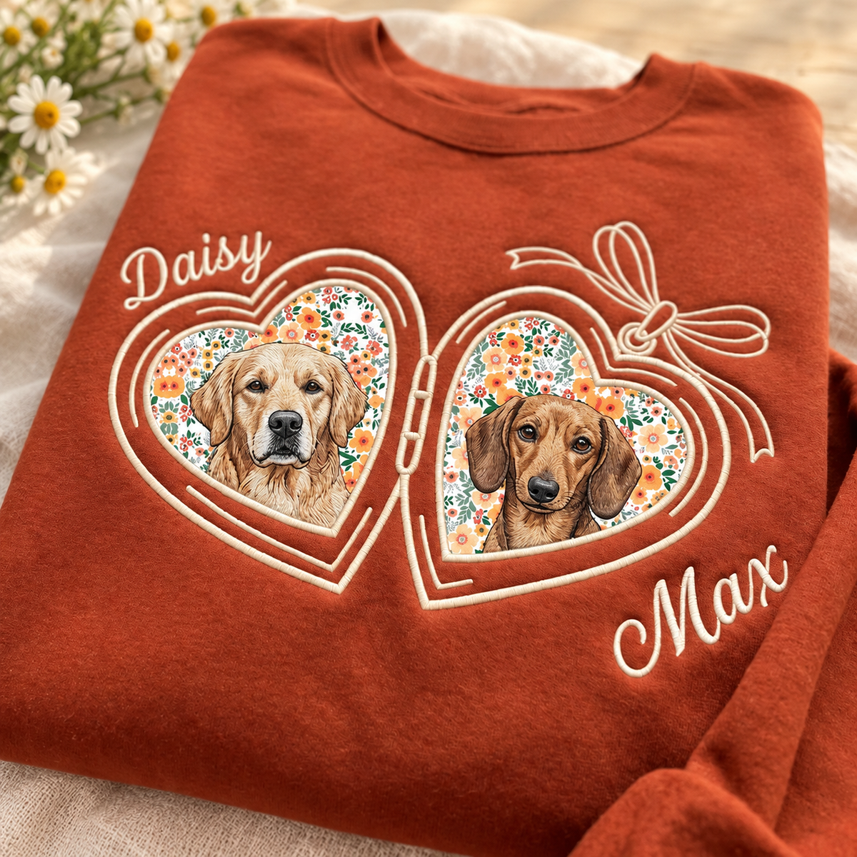 Rust orange sweatshirt with Daisy and Max pet portraits in floral heart lockets and an embroidered bow