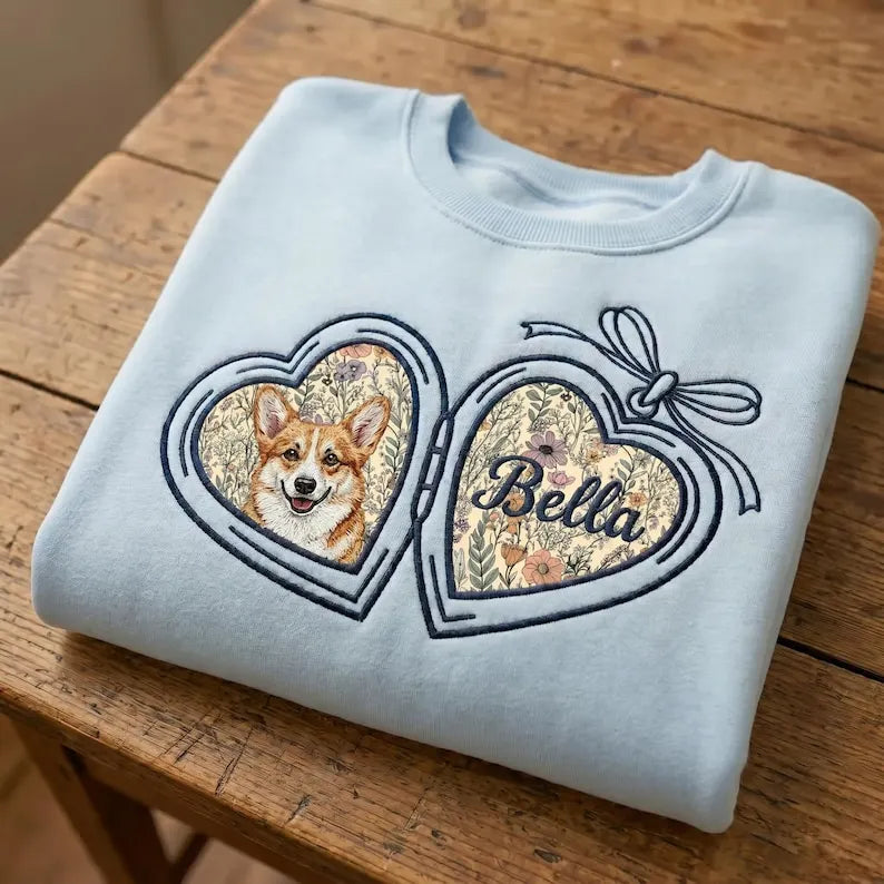 Pale blue sweatshirt with a dog portrait and Bella name in floral heart lockets