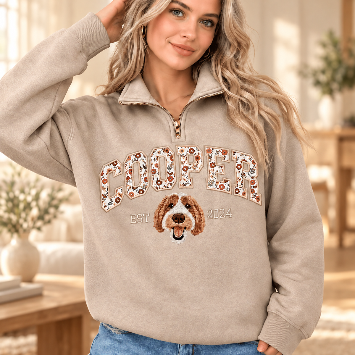 Female model wearing sand COOPER floral applique pet portrait quarter-zip sweatshirt in a warm indoor setting