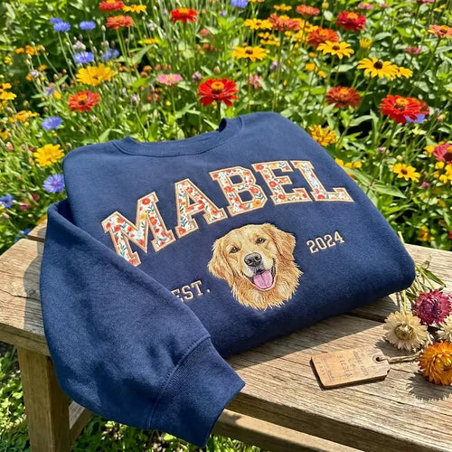 Navy sweatshirt with MABEL in floral fabric letters and an embroidered golden retriever, in a flower garden