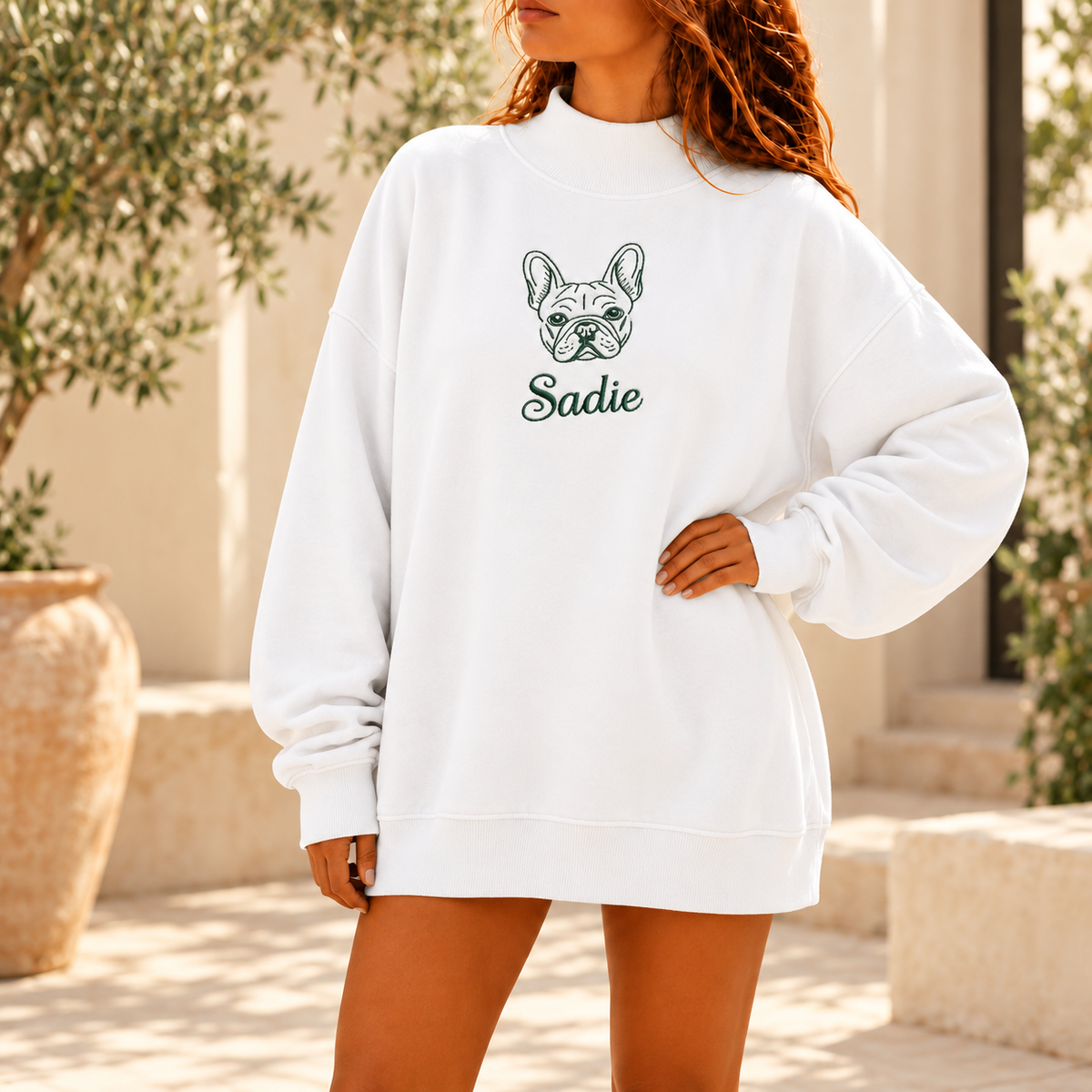 White custom pet outline and name mockneck sweatshirt in a sunlit courtyard