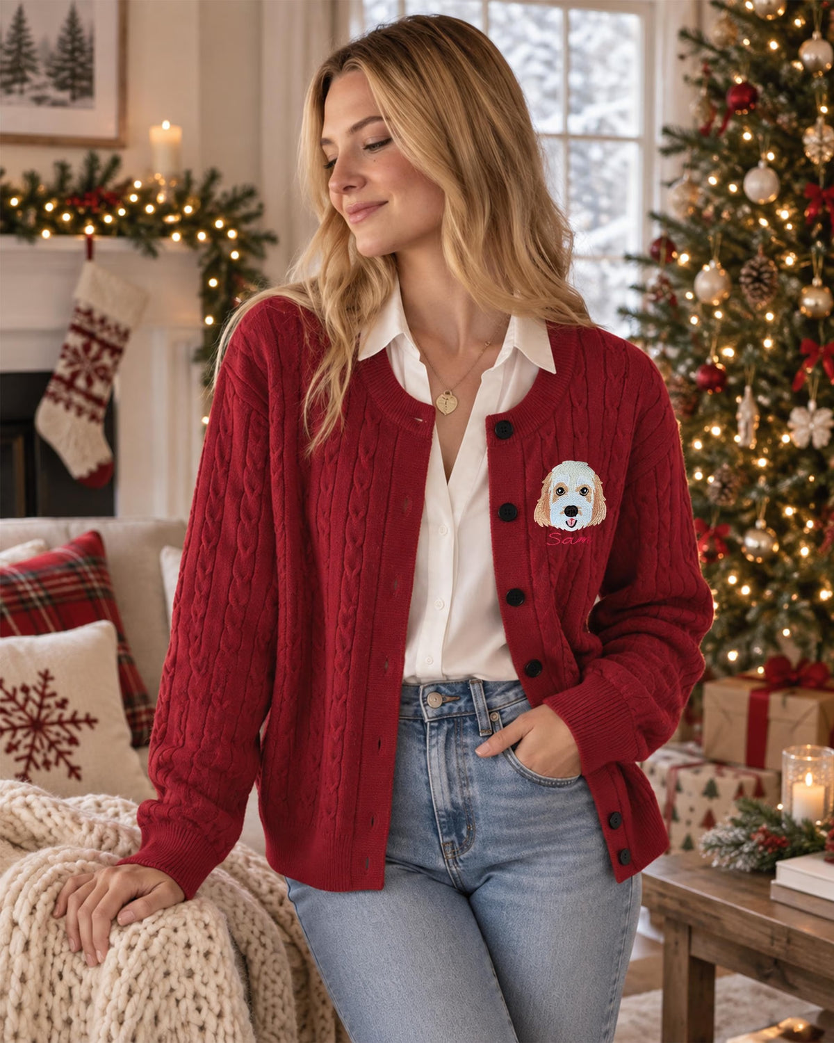 Model seated wearing red cable-knit dog portrait cardigan