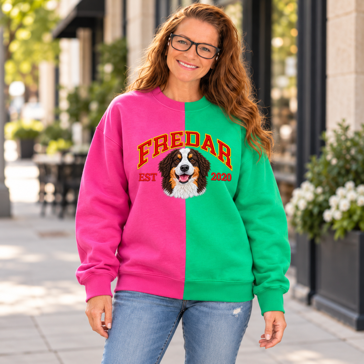 Model wearing magenta and green split color pet portrait sweatshirt with FREDAR varsity name and EST 2020