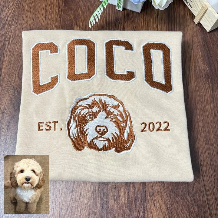 Cream sweatshirt with COCO in brown varsity letters above an embroidered doodle outline, with the original photo