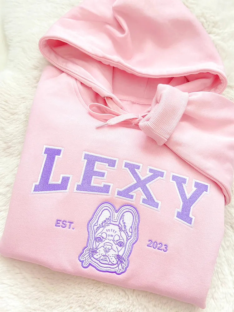 Pink hoodie with LEXY in lavender varsity letters above an embroidered French bulldog outline