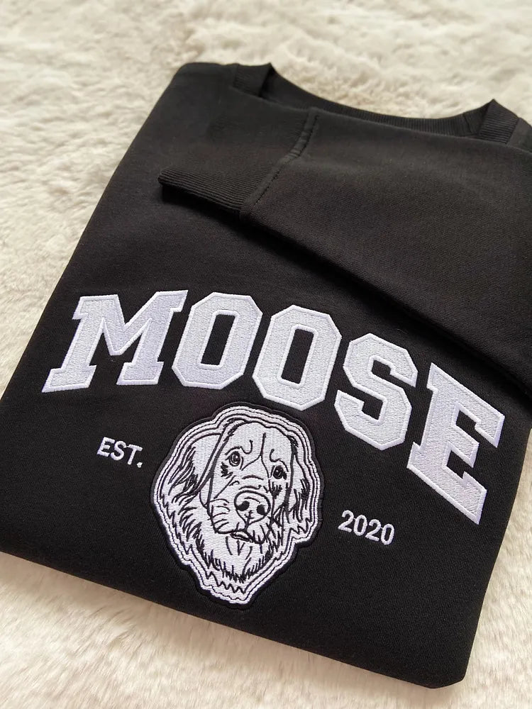 Black sweatshirt with MOOSE in white varsity letters above a white embroidered dog outline