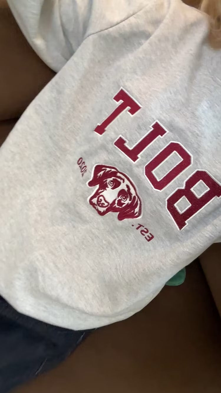 Close-up of BOLT varsity letters and a maroon Labrador outline on a gray sweatshirt