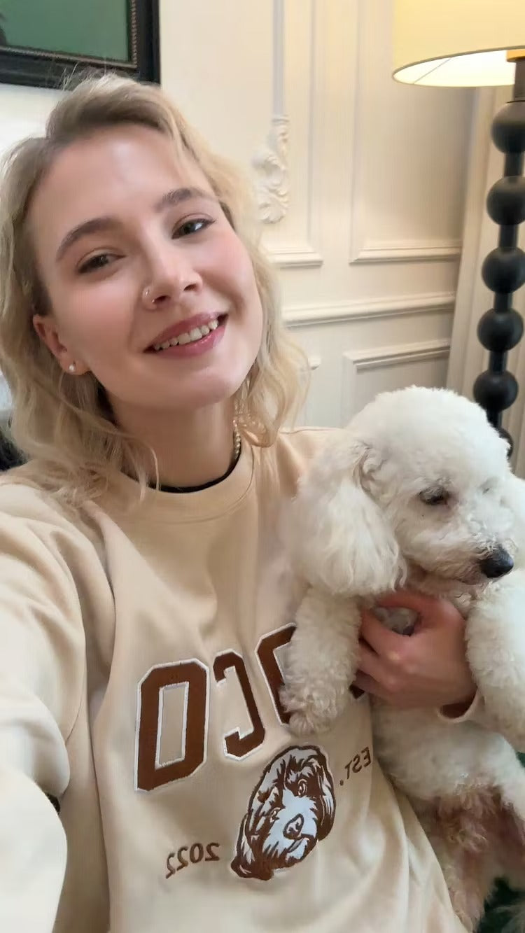 Woman smiling with her poodle in a cream COCO pet outline sweatshirt